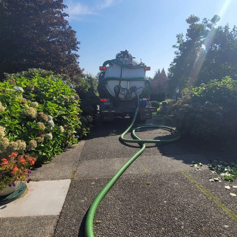Vac truck crew working with safe jobsite setup for a Langley septic service visit.